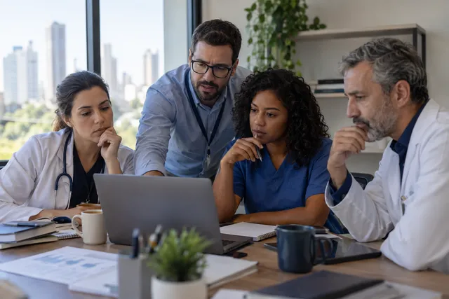 Equipe discutindo responsabilidades no uso de tecnologia em saúde.
